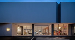 Modern storefront with glass windows, metal accents, and concrete detailing.