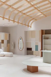 A minimalist retail shop featuring curved wooden structures and fabric elements.