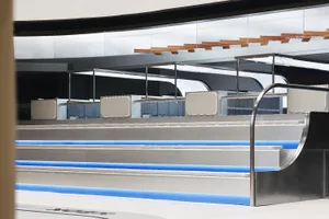 A sleek, metallic bar counter with blue lighting in a modern commercial interior.