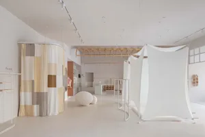 A minimalistic retail space featuring a hanging tent structure and geometric shapes.