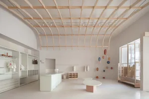 A modern minimalist retail store with white walls and light wooden accents.
