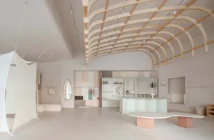 Modern retail store interior with minimalist design, featuring concrete and pastel colors, and a unique wooden ceiling struct