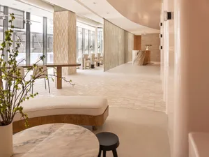 Modern entrance to a spa featuring marble flooring and seating areas.