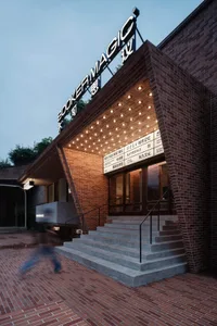 A modern staircase with a brick exterior features a series of steps leading up to a series of glass doors.