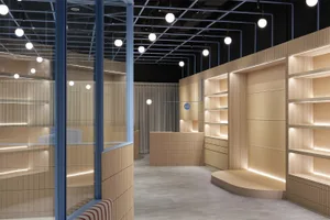 Modern, minimalist storefront interior with wooden shelves and striped accents.
