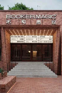 A brick building with a sign reading 'Booker Magic' and a marquee listing various amenities.