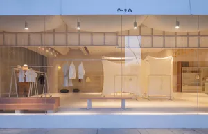 A minimalist retail shop interior with glass storefront and merchandise display.
