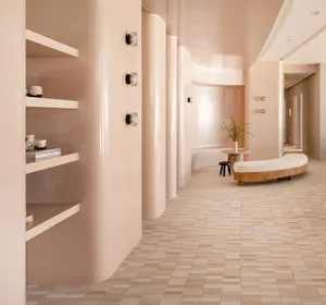A modern interior space featuring a curved wall, shelves, and a curved bench with a plant, all set against a tile flooring ba
