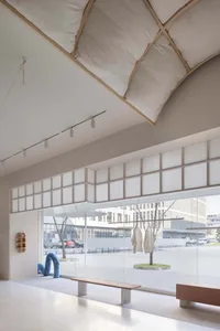 Minimalist retail store with fabric installations and glazed windows