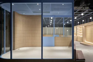 Modern coffee shop interior with wooden tiles and concrete floor.