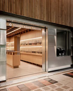 Modern storefront with a wall display of knives in a Tojiro Knife Gallery retail store