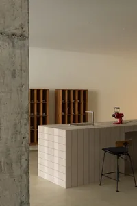 Modern minimalist residential kitchen with wooden shelves and tiled countertop.