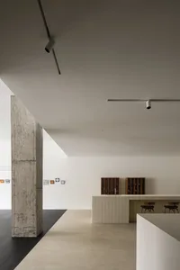 A modern interior space with concrete columns, tiled countertops, and minimalist design elements.