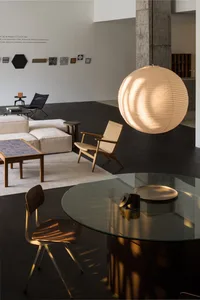 Modern minimalist living room featuring glass and wood furniture and decor.