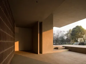 A minimalist building interior featuring concrete columns and a natural light-filled space.