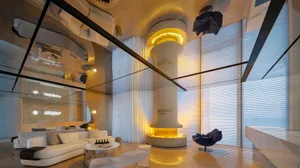 Modern living room with glass, concrete, and mirrored elements.