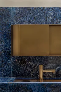 Modern bathroom featuring blue granite and brass faucet