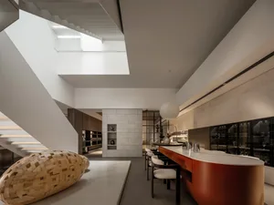 Minimalist modern kitchen featuring marble countertops and stainless steel appliances.