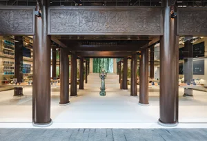 A modern retail store with wooden columns and a central statue.