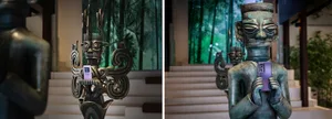 Bronze statues holding smartphones in a modern interior setting.