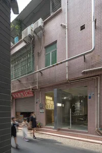 Modern retail storefront with pink tiled facade and air conditioning units attached to the wall.