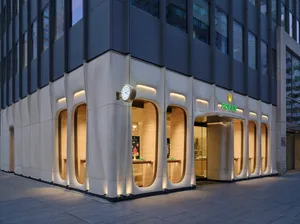 A modern retail storefront with illuminated doors and windows, showcasing sleek architectural design.