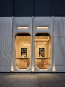 A modern storefront featuring glass display windows with illuminated signage and showcases.
