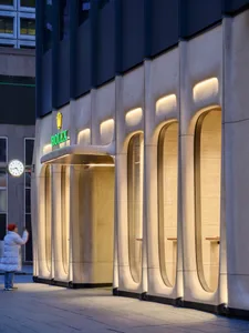 A modern retail storefront with concrete walls and illuminated entrance.