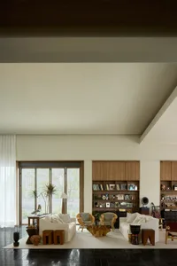 Modern minimalist living room featuring white couches, wooden furniture, and glass coffee table.