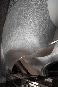 A modern, curved metallic staircase with a sleek, futuristic design