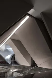 A modern architectural space featuring glass walls and steel structures.