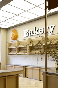 Modern bakery with wooden shelves and a sign reading 'Bakery'.