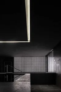 A modern interior featuring a black metal wall lattice, minimalist design, and geometric shapes.