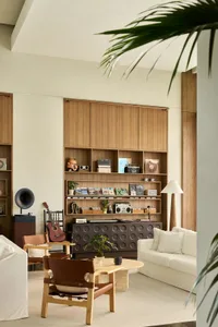 A modern minimalist living room featuring wood furniture and decor.