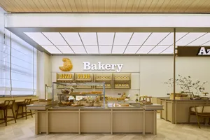A minimalist bakery interior featuring light-colored wooden materials.