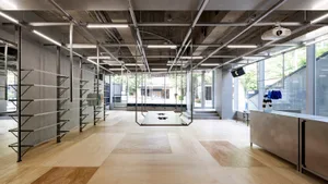 Modern retail space with concrete walls, metal shelving, and wooden flooring.