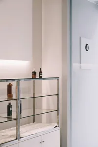 A modern showroom interior featuring glass shelves, metal accents, and a fluffy white surface.