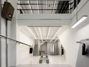 Modern retail store with concrete and glass architecture, featuring minimalist design and industrial touches.