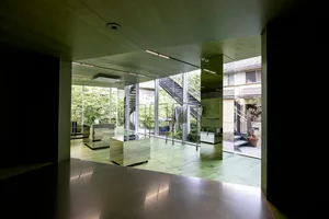 A modern interior space featuring glass walls and floors, with a commercial office or gallery setting.