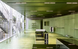 Modern retail store interior with green wooden walls and shelves.