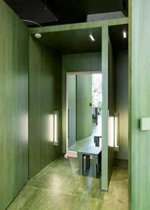 A minimalist interior design with green timber flooring and walls.