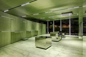 A modern office space featuring green walls and a concrete floor.