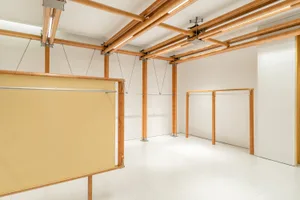 A minimalist modern interior with wooden columns and white walls.