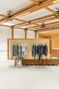 Modern minimalist clothing store interior with bamboo materials and design.