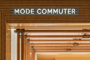 Modern interior design featuring wooden signage with the text 'MODE COMMUTER'