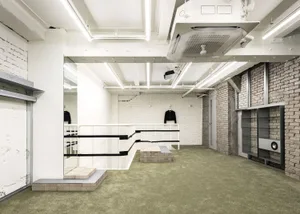 A minimalist, industrial retail space with concrete walls and floors.