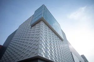 A modern office building with a glass exterior, designed to provide a sleek and contemporary aesthetic.