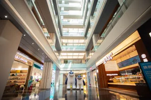 A modern mall interior featuring glass, metal, and concrete elements.