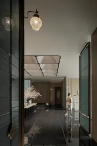 A minimalist interior featuring concrete walls and flooring, with a person walking through the space.