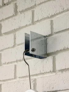 Metal lighting fixture mounted on a white brick wall